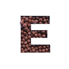 Letter E of English alphabet of nutritional chocolate cereal balls, white cut paper. Typeface for...