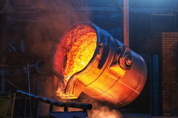 Big ladle container with molten liquid metal or iron in foundry close up.