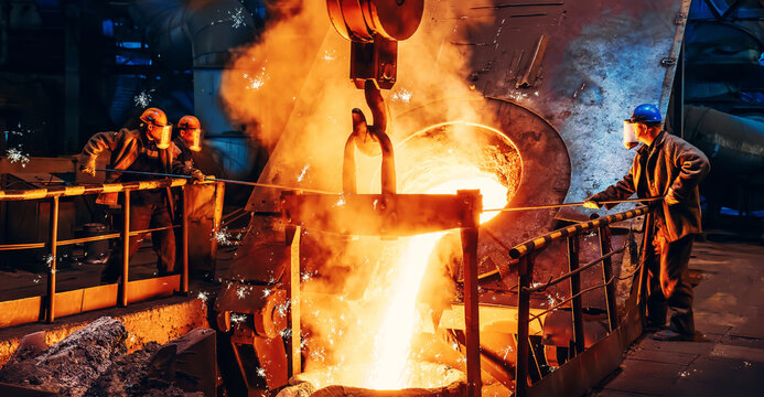 Cast iron process, liquid molten metal pouring in ladle, industrial metallurgical foundry factory, heavy industry.