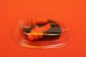 Silicone ear plugs for human ears on red background