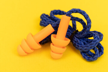 Silicone ear plugs for human ears on yellow background
