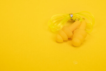 Silicone ear plugs for human ears on yellow background