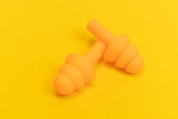Silicone ear plugs for human ears on yellow background