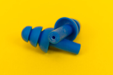 Silicone ear plugs for human ears on yellow background