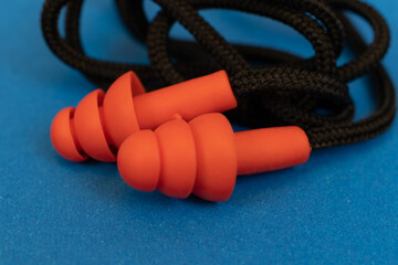 Silicone ear plugs for human ears on blue background
