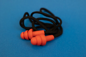 Silicone ear plugs for human ears on blue background