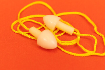 Silicone ear plugs for human ears on red background