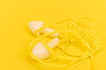 Silicone ear plugs for human ears on yellow background