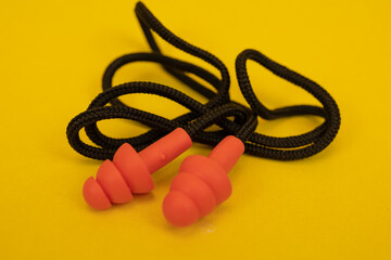 Silicone ear plugs for human ears on yellow background