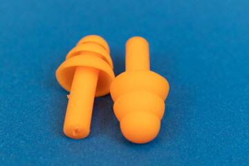 Silicone ear plugs for human ears on blue background