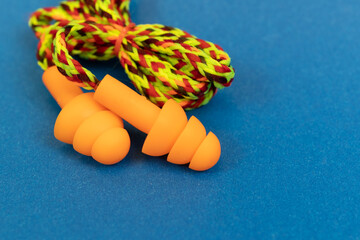 Silicone ear plugs for human ears on blue background