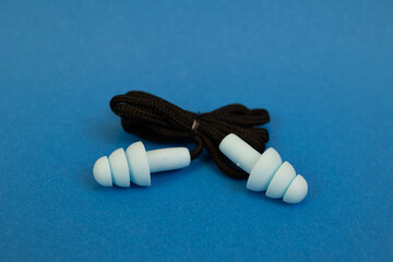 Silicone ear plugs for human ears on blue background