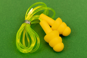 Silicone reusable ear plugs for human ears on green background