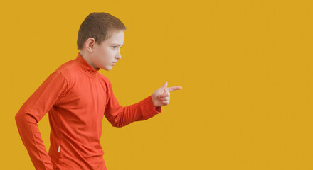 boy in an orange turtleneck runs on a yellow background