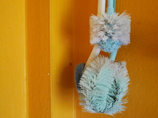 toilet brush hanging on the cement wall.
