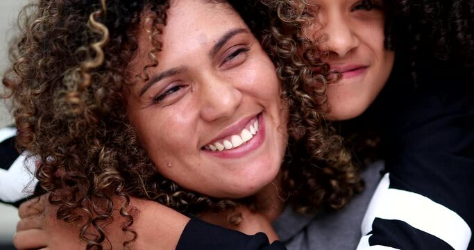 Daughter hugging mother, child embrace mom. Happy diverse mixed race family