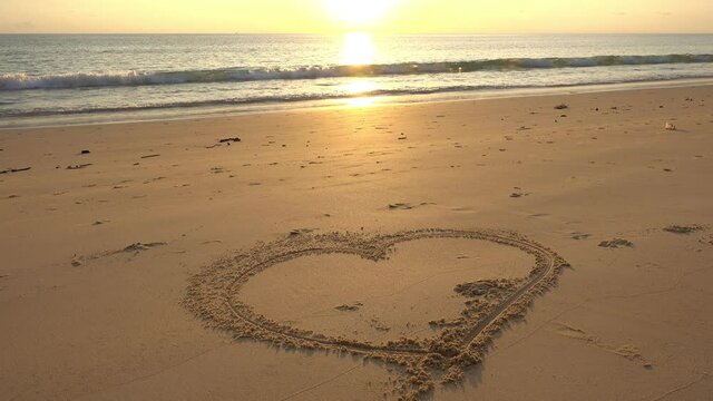 Heart symbol on beach, Hand drawn heart on beach sand over sunset or sunrise sky beautiful light nature landscape