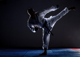 One karate kata training man isolated on dark background © qunica.com