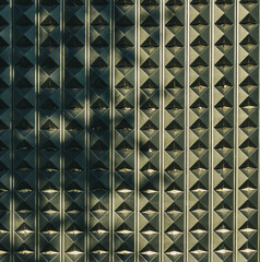 3D black diamond shaped plastic wall panelling against a concrete wall, on the outside of a warehouse. Abstract, background. 