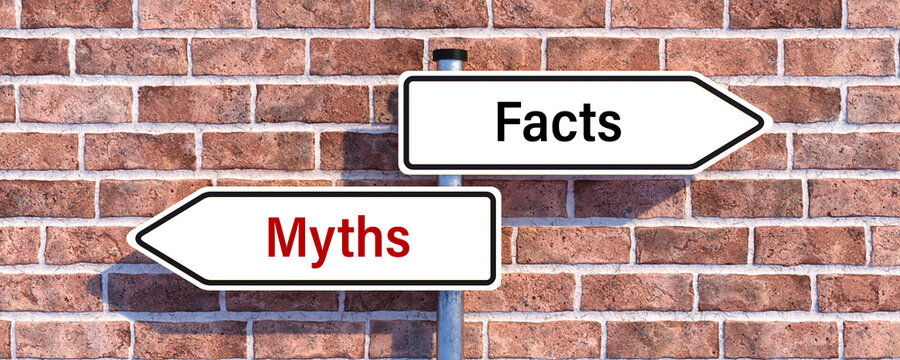 road signs with message MYTHS and FACTS showing the direction in front of a brick wall background