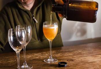 Man serving beer with a growler. Fresh homebrew beer on a glass.