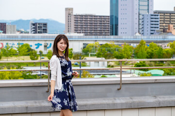 広島市の町を背景に笑顔の女性