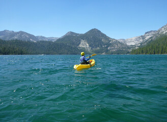 Kayaker in lake with mountains in background