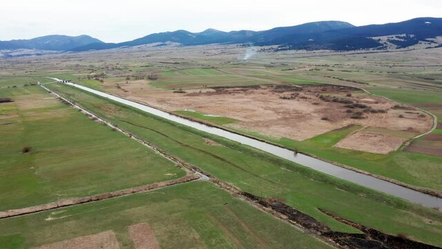 AERIAL - Olt River, countryside with the Harghita Mountains, Romania, wide shot