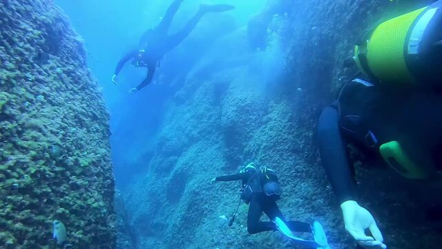 Divers enjoying the sceneries under the sea of Menorca Island Spain. underwater