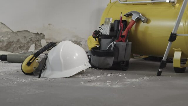 house renovation concept, helmet and safety headphones, air compressor and construction tools, video panning