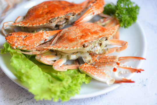 Steamed or boiled Blue Swimming Crab ocean gourmet with salad vegetables lettuce, Fresh seafood crab on white plate cooking food in the restaurant