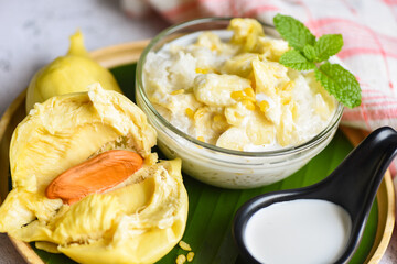 Asian Thai dessert tropical sweet durian peel with yellow bean on wooden plate and fresh mint leaves, Ripe durian rice cooked with coconut milk, Durian sticky rice summer tropical fruit food