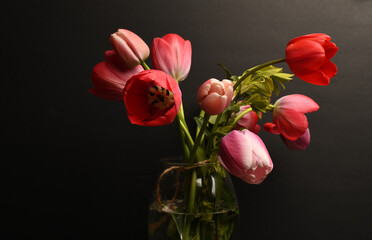 Obraz premium Bouquet of red tulips in a glass vase