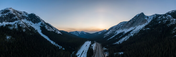 Aerial Panoramic View of a scenic Highway passing in the Canadian Mountain Landscape during a colorful spring sunset. Taken near Hope and Merritt, British Columbia, Canada.