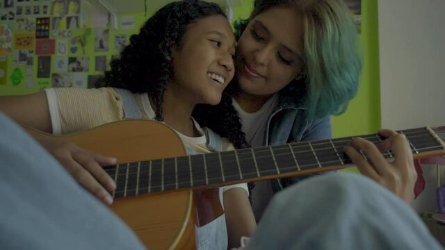 Joven lesbiana cantando y tocando guitarra para su novia 