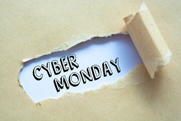 Cyber Monday appearing behind ripped brown paper.
