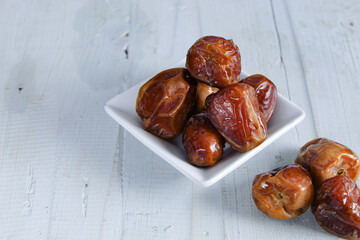 Dates fruits on white wooden table, with copy space. Organic dried dates fruits.