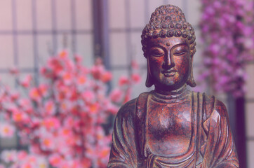 Buddha Statue in Asian Style Room With Cherry Blossoms in Background