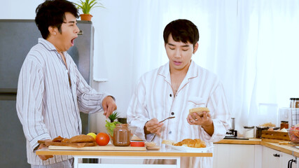 Asian gay couple homosexual cooking together in the kitchen prepare fresh vegetable make organic salad healthy food. Asian people happy time smile, laugh in kitchen. LGBTQ relation lifestyle concept