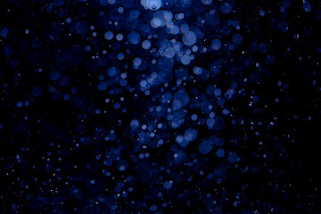 Glittering stars of blue bokeh with black background