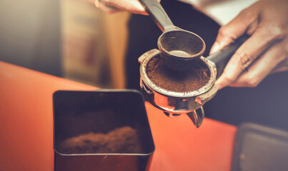 Close up of professional barista.Woman making espresso with clearing old coffee grain out from portafilter