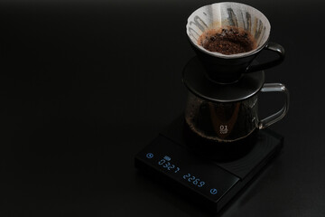Hand driper of Prepare drip coffee on digital scale in Studio dark tone.