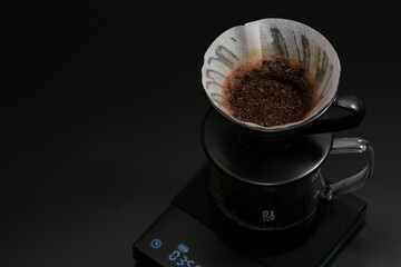 Obraz na płótnie Canvas Hand driper of Prepare drip coffee on digital scale in Studio dark tone.