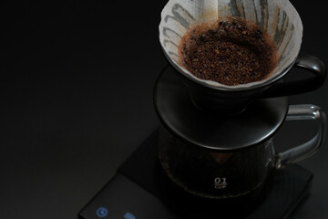 Hand driper of Prepare drip coffee on digital scale in Studio dark tone.