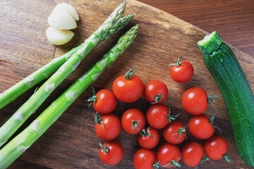 木製のまな板に乗ったオリーブオイルで調理すると美味しい野菜の俯瞰写真