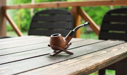Smoking pipe on a wooden table