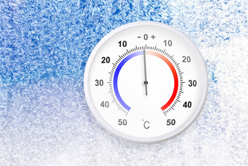 Celsius scale thermometer on a frozen window shows minus 1 degrees