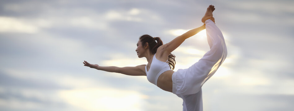 Asian young woman practicing easy yoga poses for beginners. Exercise while looking out to the sky. Stretching and Strengthening Exercises with yoga. Banner size with copy space.