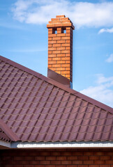 Brick pipe on the roof of a private house.