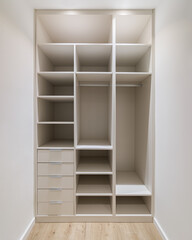 New built-in furniture in a small dressing room. Modern storage room with wardrobe, many shelves...